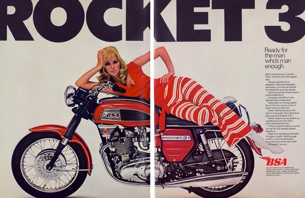 Red BSA Rocket 3 motorcycle spans a two-page spread beneath huge ROCKET 3 lettering, with a woman reclining across its seat.