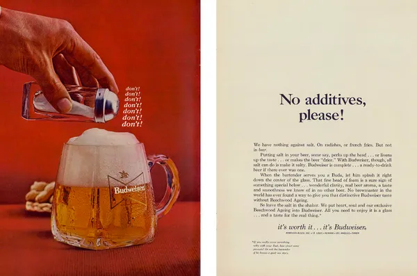 A salt shaker hovers over a foaming Budweiser mug on a red background beside a cream page of copy.