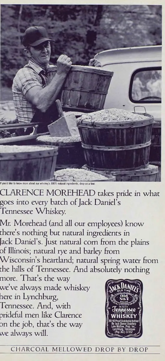 Black-and-white photograph of Clarence Morehead lifting a wooden grain basket beside a truck, above whiskey ingredient copy and a Jack Daniel’s label.