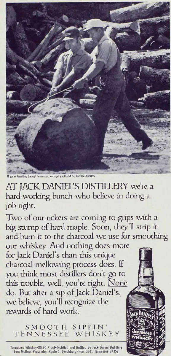 Two distillery workers manoeuvre a large maple stump in a black-and-white photograph above copy about charcoal mellowing and a Jack Daniel's bottle illustration.