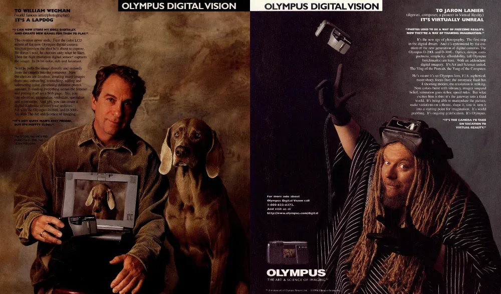 Two-panel Olympus digital camera spread: William Wegman with a dog and computer on the left, Jaron Lanier wearing a virtual-reality headset on the right.