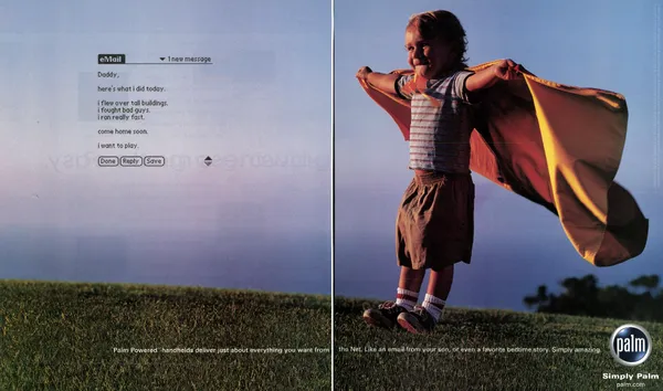 A child's email floats beside a photograph of a boy wearing a makeshift superhero cape in a grassy field.
