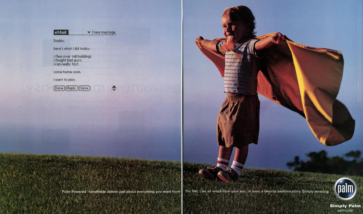 A child's email floats beside a photograph of a boy wearing a makeshift superhero cape in a grassy field.