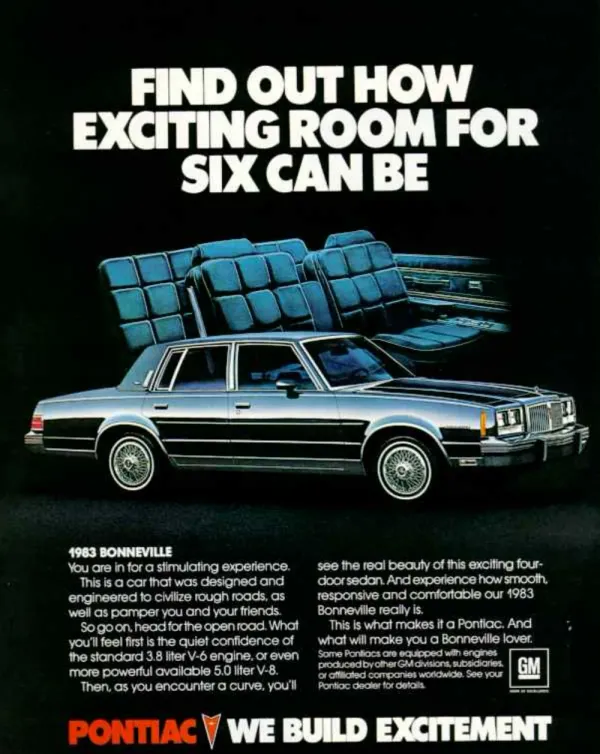A silver 1983 Pontiac Bonneville sits below floating blue seat cushions against a black field.