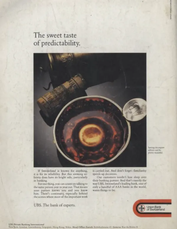 UBS private banking ad with a dark drink, bottle and corkscrew beneath the headline The sweet taste of predictability.