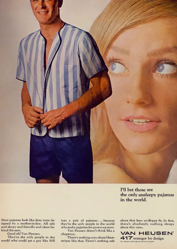 A man in striped short pajamas stands beside an oversized portrait of a woman looking toward him.